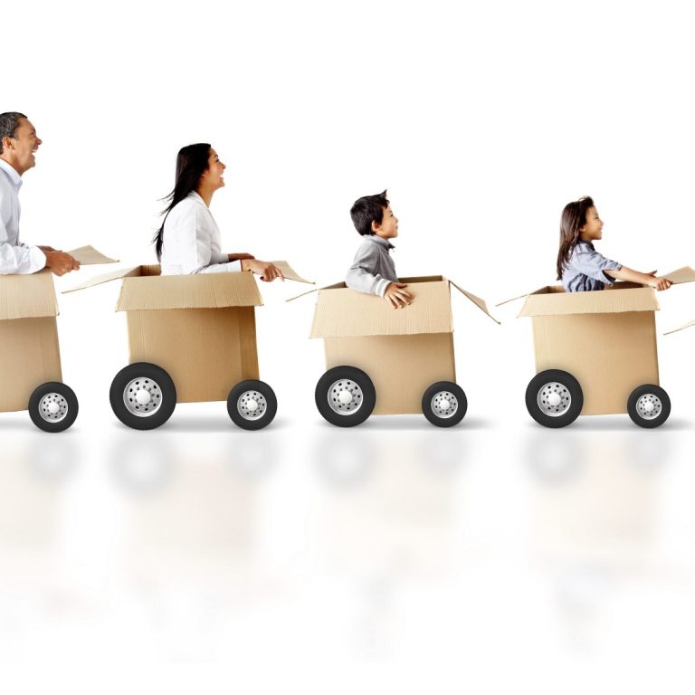 Eine Familie fährt in Kartons auf Rollen mit fröhlichen Gesichtern.